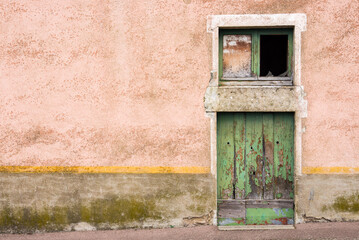 Vieille fa&ccedil;ade de maison. Vieille porte verte et ligne jaune. Ancienne maison au cr&eacute;pi rose. R&eacute;sidence abandonn&eacute;e. Abandon rural. D&eacute;sertification 