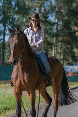Fototapeta premium Portrait of a young beautiful dark-haired girl with a horse outdoors.