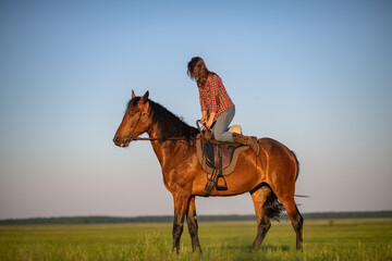 Portrait of a young beautiful dark-haired girl with a horse outdoors.