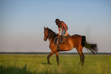 Portrait of a young beautiful dark-haired girl with a horse outdoors.