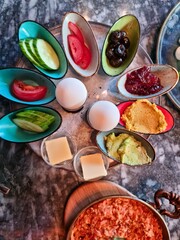 A beautifully presented vegetarian breakfast on a wooden platter with hummus salad and egg.