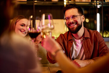 Joyful Friends Toasting Wine Glasses at Cozy Restaurant