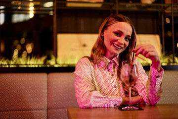 Smiling Woman Enjoys A Relaxing Evening in a Stylish Bar