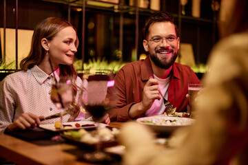 Friends Enjoying Dinner and Drinks in a Cozy Restaurant Setting