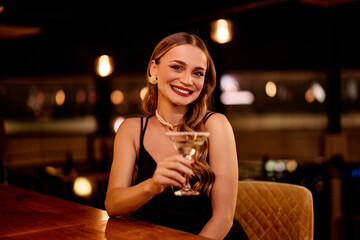 Elegant Woman Enjoys Cocktail at Upscale Bar in Evening