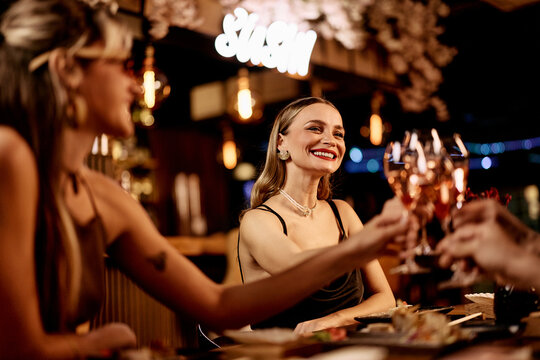Joyful Group Toasting with Wine at Elegant Dinner Gathering