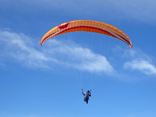 Paraglider flying in a blue sky	