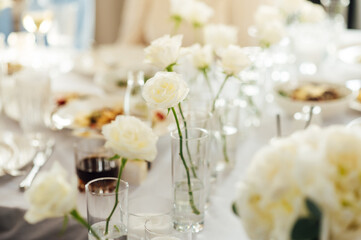 Elegant neutral coloured wedding table scape with flowers and candles