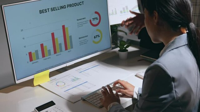 Businesswomen analyzing a graph on a computer screen, focusing on the best selling product and discussing sales strategies