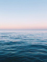 Obraz premium A peaceful ocean scene with gentle waves rippling under a soft sunset sky, creating a calm and tranquil atmosphere.