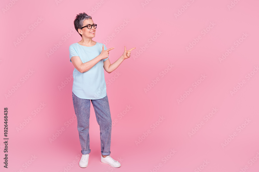 Canvas Prints Portrait of pretty aged lady point fingers empty space blue t-shirt isolated on pink color background