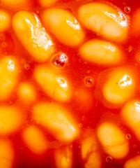 Baked beans in tomato sauce,close up top view,warmed and ready to serve.