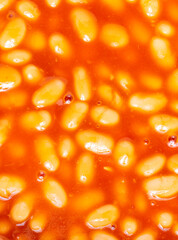Baked beans in tomato sauce,close up top view,warmed and ready to serve.