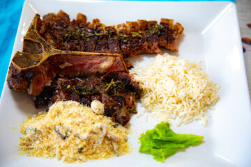 Grilled T-Bone with farofa, rice, traditional Brazilian farofa, straw potatoes and a little salad...