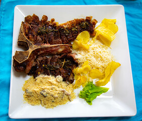 Grilled T-Bone with farofa, rice, traditional Brazilian farofa, straw potatoes and a little salad...