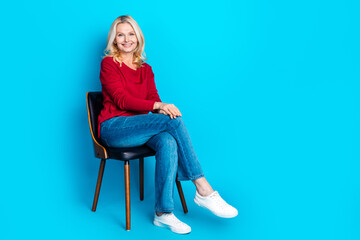 Full length photo of lovely pensioner lady sit chair dressed stylish red garment isolated on blue...