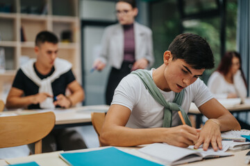 A group of focused students engage in writing tasks at their desks, supervised by a teacher. The classroom setting promotes concentration and learning, highlighting the educational atmosphere and