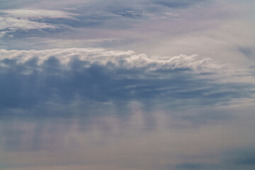 A serene sky is filled with fluffy clouds and silhouetted birds gracefully flying above