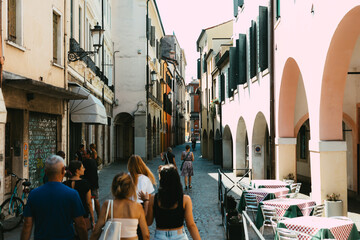 a group of people walking down the street in a quaint Italian city