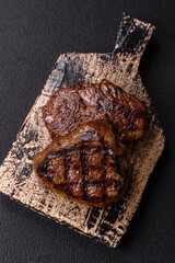 Juicy beef steak baked on the grill with salt, spices and herbs