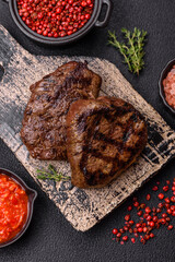 Juicy beef steak baked on the grill with salt, spices and herbs