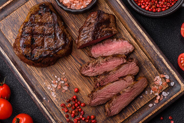 Juicy beef steak baked on the grill with salt, spices and herbs