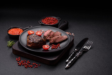 Juicy beef steak baked on the grill with salt, spices and herbs