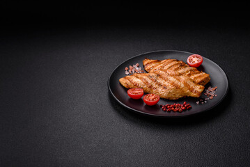 Juicy chicken fillet baked on the grill with salt, spices and herbs