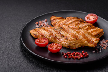 Juicy chicken fillet baked on the grill with salt, spices and herbs