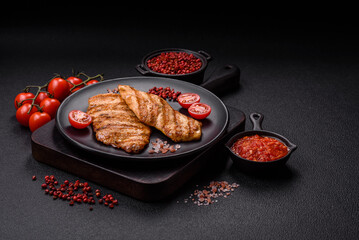 Juicy chicken fillet baked on the grill with salt, spices and herbs