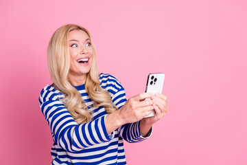 Photo of adorable cheerful woman wear trendy striped clothes hold modern device isolated on pink color background