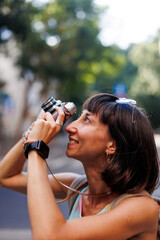 girl taking pictures. Girl walking around the city taking pictures with a camera. young girl with a film camera in the city.  Close-up of a film camera.