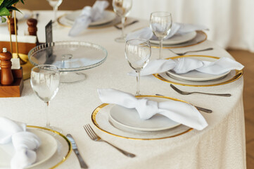 Luxurious restaurant. Luxurious interior, white tables, serving dishes and glasses for guests
