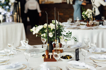 Luxurious restaurant. Luxurious interior, white tables, serving dishes and glasses for guests