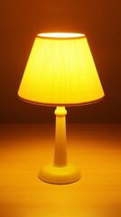 A white table lamp with a beige lampshade is turned on, casting a warm yellow glow on a wooden surface.