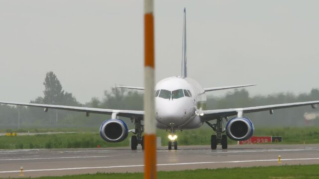 Jet airplane taxiing on the airfield, side view. Passenger jet on the runway