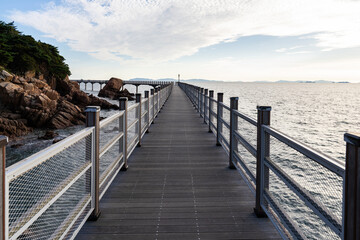 Fototapeta premium walkway bridge at the seaside during sunset