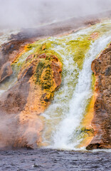 Stunning Thermal Waterfall Emerging From Vibrant Mineral-Laden Rocks in Yellowstone National Park