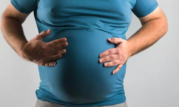 Close-up of a person holding their belly, depicting discomfort or fullness in a casual setting. AI