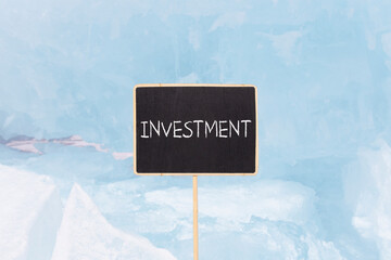 Investment symbol. Concept word Investment on beautiful chalk blackboard. Beautiful blue ice....