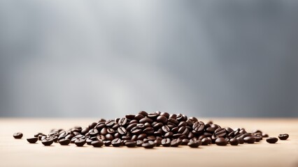 A close-up of a pile of roasted coffee beans on a wooden surface.