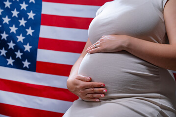 Unrecognizable future mother expecting baby on american national flag background