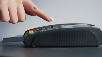 Female fingers entering pin code on terminal closeup. Woman hand inserting card