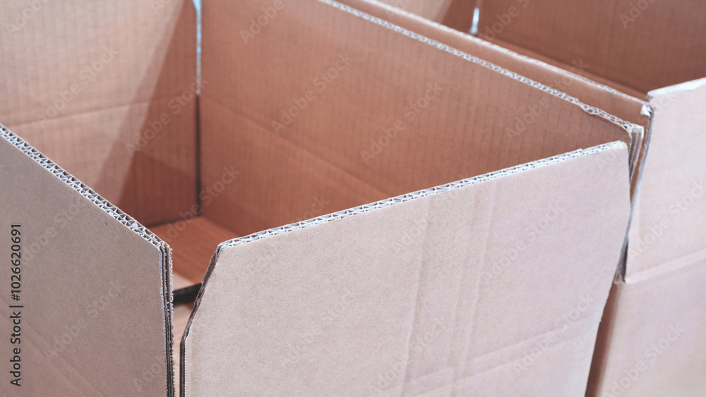 Poster cardboard boxes are stacked on top of each other. The boxes are empty and have no labels or markings. Concept of organization and efficiency, as the boxes are neatly stacked and ready for use