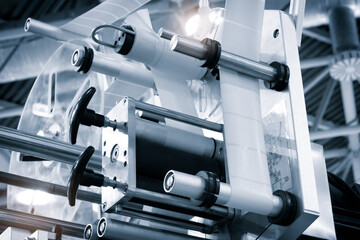 A machine with a white label on it. The machine is in a factory. The machine is used to print labels