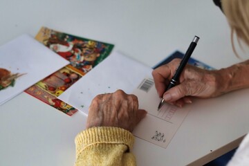 An elderly woman writing Christmas cards