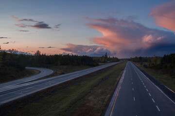 An empty stretch of the 401 highway in Ontario, Canada with a distant storm.