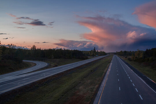 An empty stretch of the 401 highway in Ontario, Canada with a distant storm.
