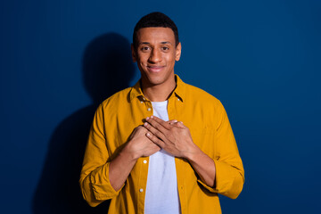 Photo of nice young man arms touch chest wear yellow shirt isolated on dark blue color background