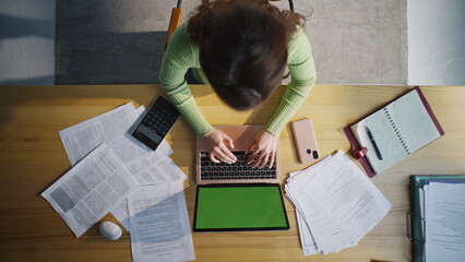 Accountant working mockup laptop top view. Woman examining documents closeup